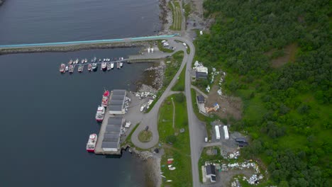 Flying-over-Husoy-harbor-with-the-camper-car-park-and-dry-fish-racks-Senja-Island
