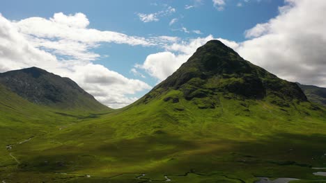 Aerial-shot-in-Scotland-of-mountain-and-valley-in-Glencoe-mountain-range-in-the-Highlands-of-Scotland-on-a-sunny-summer-day