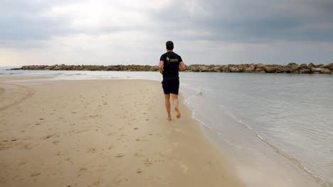 Male-running-at-the-beach,-slow-motion