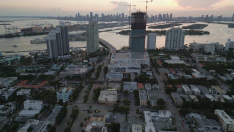 aerial-at-sunset-skyline-of-south-beach-with-downtown-cityscape-at-distance