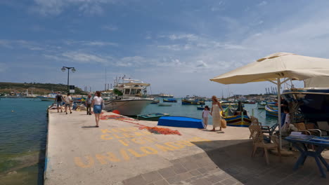 Tourists-Walk-Along-Pier-in-Valletta-to-Board-a-Boat-Trip,-Summer-Vacation,-Malta