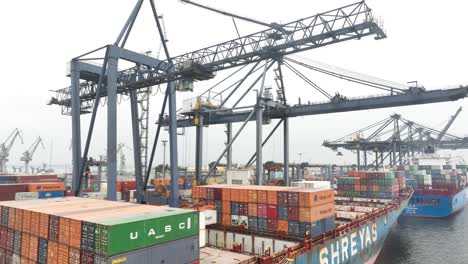 Aerial-view-of-a-great-container-ship-docked-and-downloading-the-containers-by-means-of-a-gantry-crane-in-the-port-of-Karachi,-Pakistan