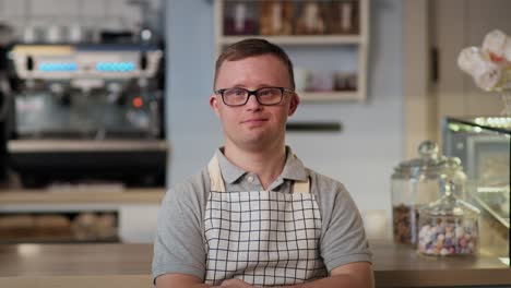 Portrait-of-caucasian-man-with-down-syndrome-working-in-the-cafe.