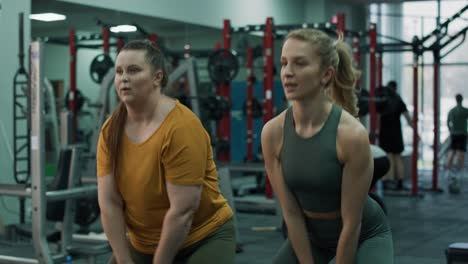 Caucasian-woman-with-overweight-doing-training-with-fitness-instructor-at-the-gym.