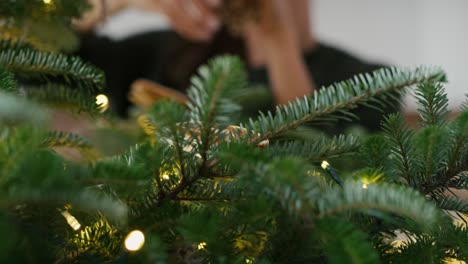 Junge-Kaukasische-Frau-Schmückt-Den-Weihnachtsbaum-Zu-Hause.