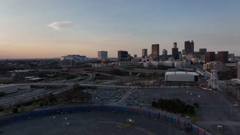 Eine-Luftaufnahme-Von-Hank-Aaron-Wall-Auf-Dem-Parkplatz-Am-Turner-Field-Mit-Blick-Auf-Die-Regierungsgebäude-Von-Atlanta,-Wolkenkratzer-Im-Hintergrund-Bei-Sonnenuntergang,-Verkehrsbewegung-Auf-Der-Autobahn-In-Der-Stadt