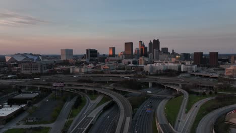 Una-Vista-Aérea-Cinematográfica-De-La-Autopista-Del-Centro-De-Atlanta-Durante-La-Hora-Pico-Con-La-Vista-De-Los-Famosos-Edificios-Del-Horizonte-Al-Fondo,-El-Tráfico-En-La-Autopista-En-Una-Ciudad-Urbana-Moderna