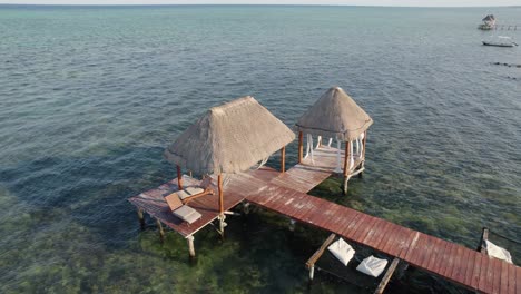 Rotating-aerial-over-small-beach-water-villa-located-at-Tulum,-at-Tankah-Bay-Beach