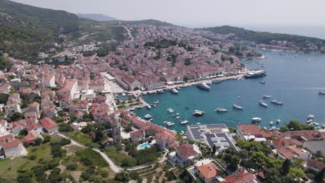 Aerial-view-of-Hvar-port,-Croatia,-boats-in-harbor,-scenic-coastline