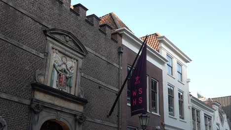 Bandera-De-Wshs-Izada-En-La-Fachada-De-Ladrillo-Del-Hotel-Relais-Y-Chateaux-Weeshuis-En-Gouda,-Países-Bajos