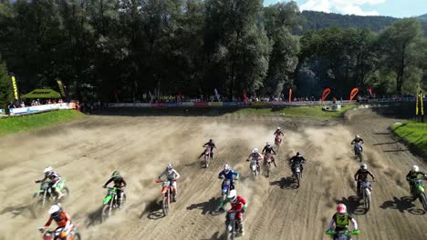 Aerial-drone-shot-of-motocross-dirtbike-motorbike-competition-start-filmed-from-above