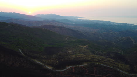A-drone-flies-over-a-burnt-mountainside-and-road-in-Pico-De-Los-Reales,-Estepona,-Spain