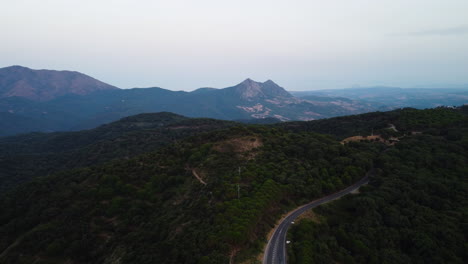 A-drone-rises-above-a-mountain-road-in-an-aerial-view