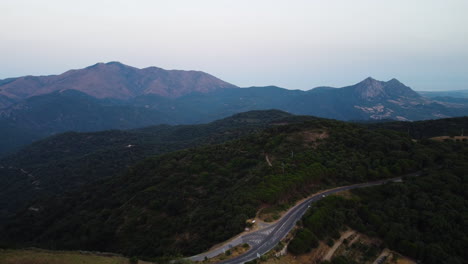 A-drone-pulls-back-over-a-mountain-road-in-Pico-De-Los-Reales-in-Estepona,-Spain