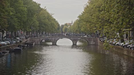 Wide-pan-of-distant-bridge-and-quays-on-Amsterdam-canal