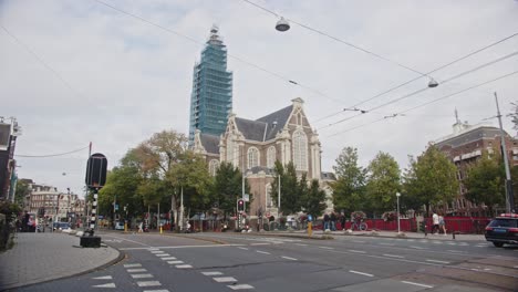 Pan-of-busy-road-in-Amsterdam-with-the-imposing-Westerkerk-in-the-background