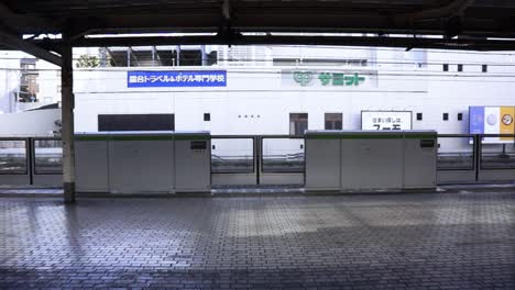 Train-station-platform-in-Tokyo-seen-from-train,-while-doors-are-closing