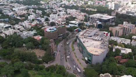 Aerial-Cinematic-Footage-of-Hyderabad-Mall-Surrounded-By-Trees,-Vehicles,-and-Buildings