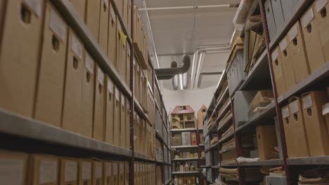 Tilt-down-of-shelves-filled-with-documents-in-old-archive