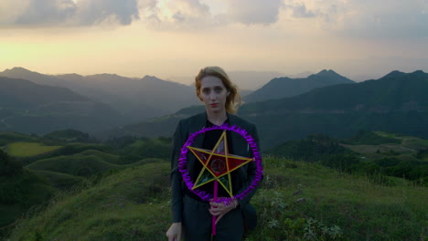Slow-motion-shot-of-a-woman-holding-a-star-lantern-and-removing-her-mask-on-a-hill