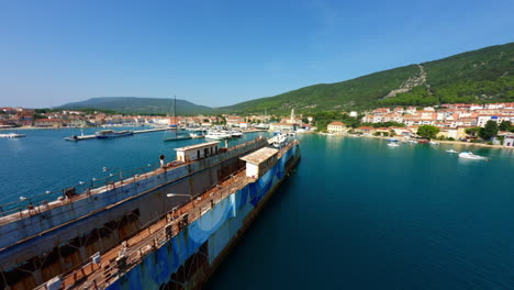 Large-rusted-transport-maritime-ship-sits-docked-outside-of-Cres-Island,-Croatia