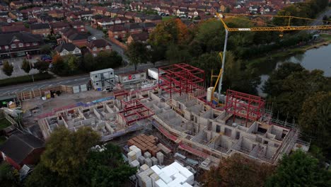 Aerial-view-crane-building-waterside-care-home-construction-development-in-rural-British-village