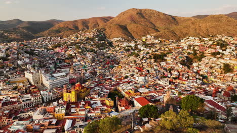 Aerial-overview-of-the-El-Pipila-Statue-and-the-cityscape-of-Guanajuato,-in-sunny-Mexico