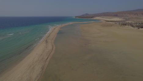 Sotavento-Beach,-Fuerteventura:-wonderful-aerial-view-traveling-in-on-the-shore-of-the-fantastic-beach,-on-a-sunny-day