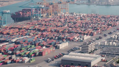 Luftaufnahmen-Des-Frachthafens-Von-Barcelona:-Lebhaftes-Containerdepot-In-Aktion,-Automatische-Maschinen-Laden-Und-Entladen-Waren