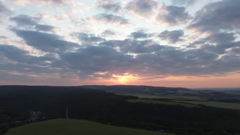 Drohnenansicht-Des-Sonnenaufgangs-Mit-Bewölktem-Himmel-Und-Bergen-Im-Hintergrund