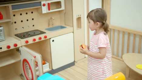 Kleinkind-Des-Kleinen-Mädchens-Tut-So,-Als-Koche-Es-Burger-In-Der-Spielzeugküche-Der-Kinder-Zu-Hause