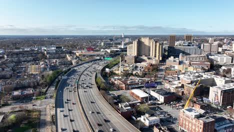 Filmische-Drohnenaufnahme-Der-Stark-Befahrenen-Autobahn-In-Der-Innenstadt-Von-Atlanta,-Der-Skyline-Gebäude,-Der-John-Lewis-Wandmalerei-Und-Der-Historischen-Butler-Street-YMCA,-Georgia,-USA