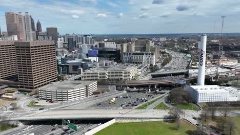 Aerial-timelapse-of-Downtown-Atlanta-highway-traffic-during-rush-hour,-Atlanta-skyline-buildings-on-a-sunny-afternoon