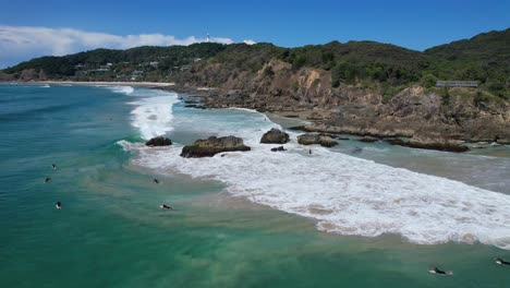 Paisaje-Marino-Escénico-Con-Surfistas-En-La-Playa-De-Clarkes,-Nueva-Gales-Del-Sur,-Australia---Toma-De-Drones