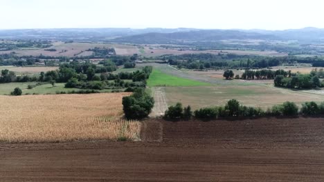 Aerial-drone-shot-of-farming-land-and-small-village-in-France