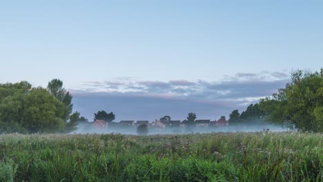 Fog-is-creeping-over-the-grass-in-the-early-morning-hours-in-Thetford,-Norfolk