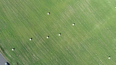 Aerial-drone-shot-of-farm-field-with-hay-bales