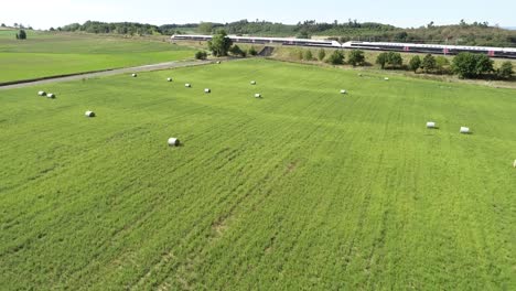 Drone-shot-of-hay-farm-with-train-in-the-background