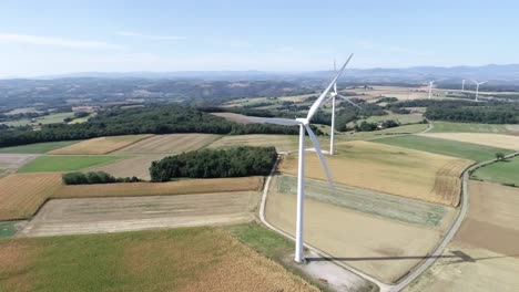 Drohnenaufnahme-Von-Windmühlen,-Die-Ihre-Flügel-Drehen,-Mit-Wunderschöner-Landschaft