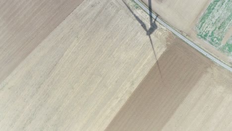 Drone-shot-of-farmland-and-windmill-with-shadow