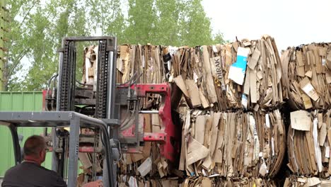 Mann-Fährt-Gabelstapler-Mit-Klemme-Und-Stapelt-Kartonballen-In-Recyclinganlage