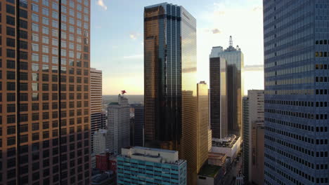 Aerial-view-rising-in-front-of-the-Santander-Tower,-sunny-evening-in-Dallas,-USA