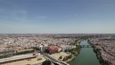 Drone-Volando-Sobre-El-Famoso-Río-Guadalquivir-En-El-Centro-De-La-Ciudad-De-Sevilla