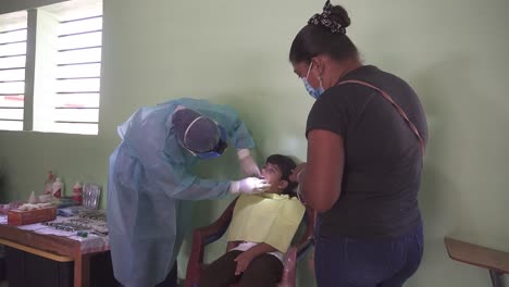 Dentist-woman-inspects-mouth-and-teeth-of-a-small-child-during-consultation-in-mobile-medical-brigade