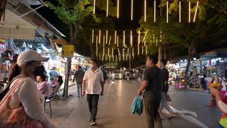 Shoppers-and-tourists-doing-a-late-night-shopping-and-window-shopping-inside-Chatuchak-Weekend-Night-Market,-in-the-city-of-Bangkok,-Thailand