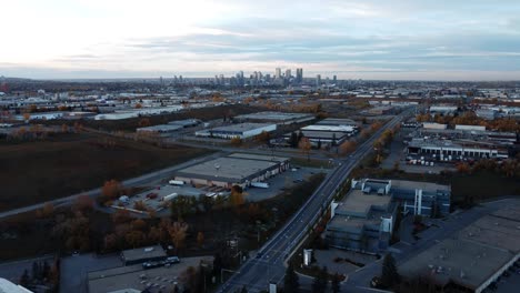 A-sunset-drone-shot-of-Calgary-Downtown-during-the-fall-season,-with-orange-trees