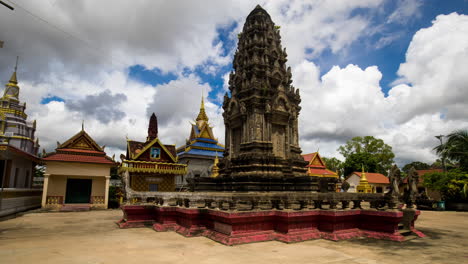 Angkorian-like-temple-structure-in-pagoda,-a-place-of-worship-during-fluffy-monsoon-clouds-building-on-blue-sky