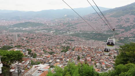 Gondola-over-stunning-downtown-of-city-Medellin,-Colombia,-pan-right