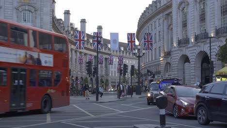 Typical-red-double-decker-bus-driving-a-circus-in-Piccadilly-Circus,-London,-UK
