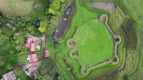 Aerial-video-footage-of-the-remains-of-Bolingbroke-Castle-a-13th-century-hexagonal-castle,-birthplace-of-the-future-King-Henry-IV,-with-adjacent-earthwork